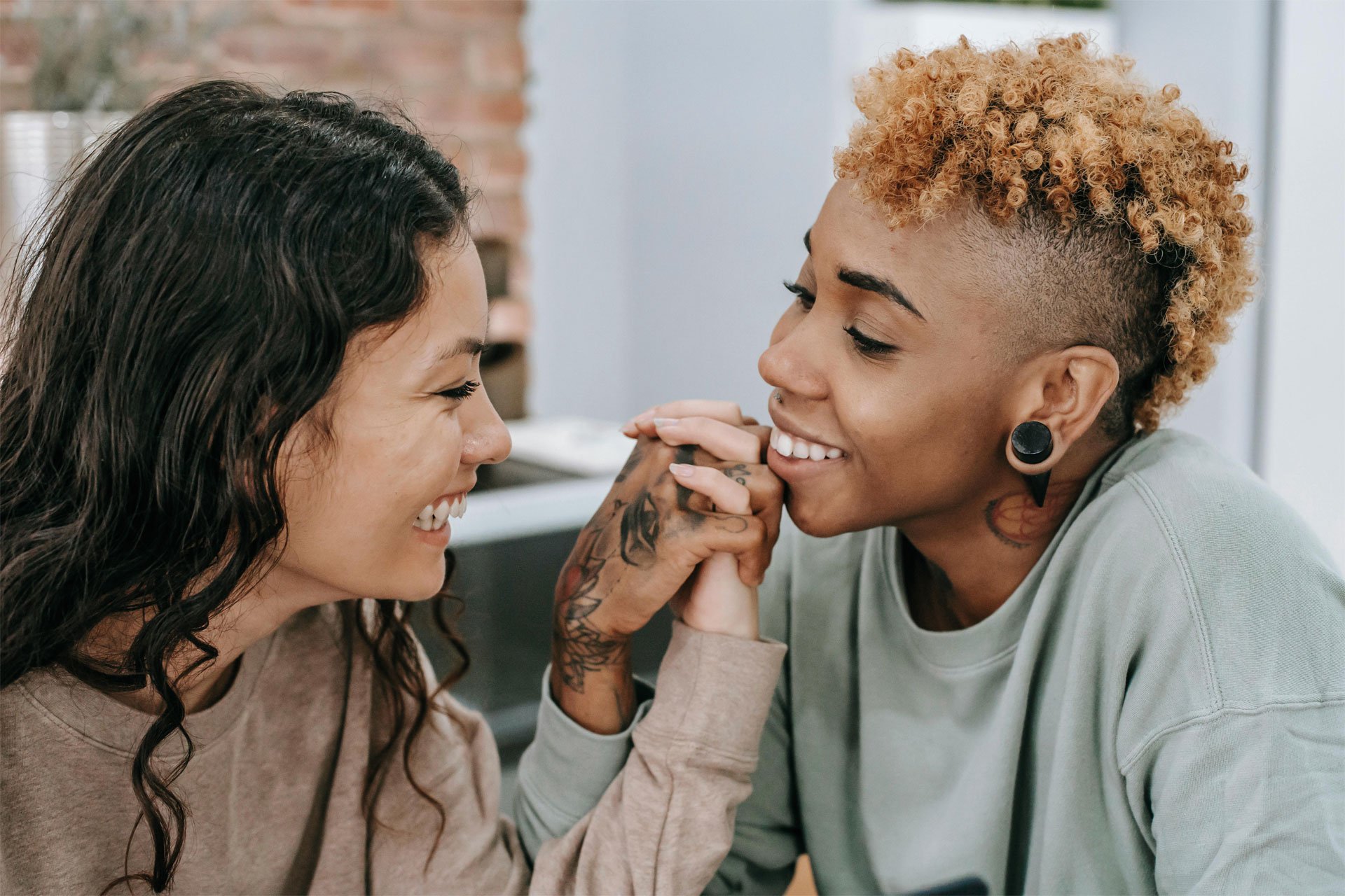 Two women holding hands and looking lovingly into each others eyes