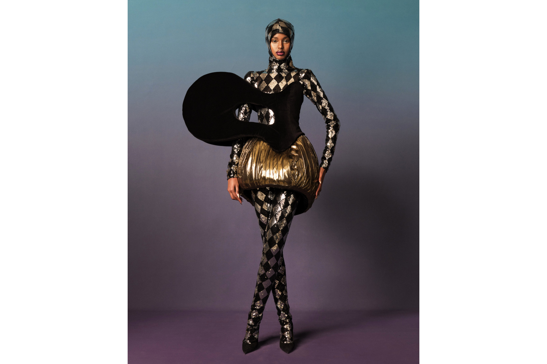Model in black and silver check bodysuit with gold skirt and black corset