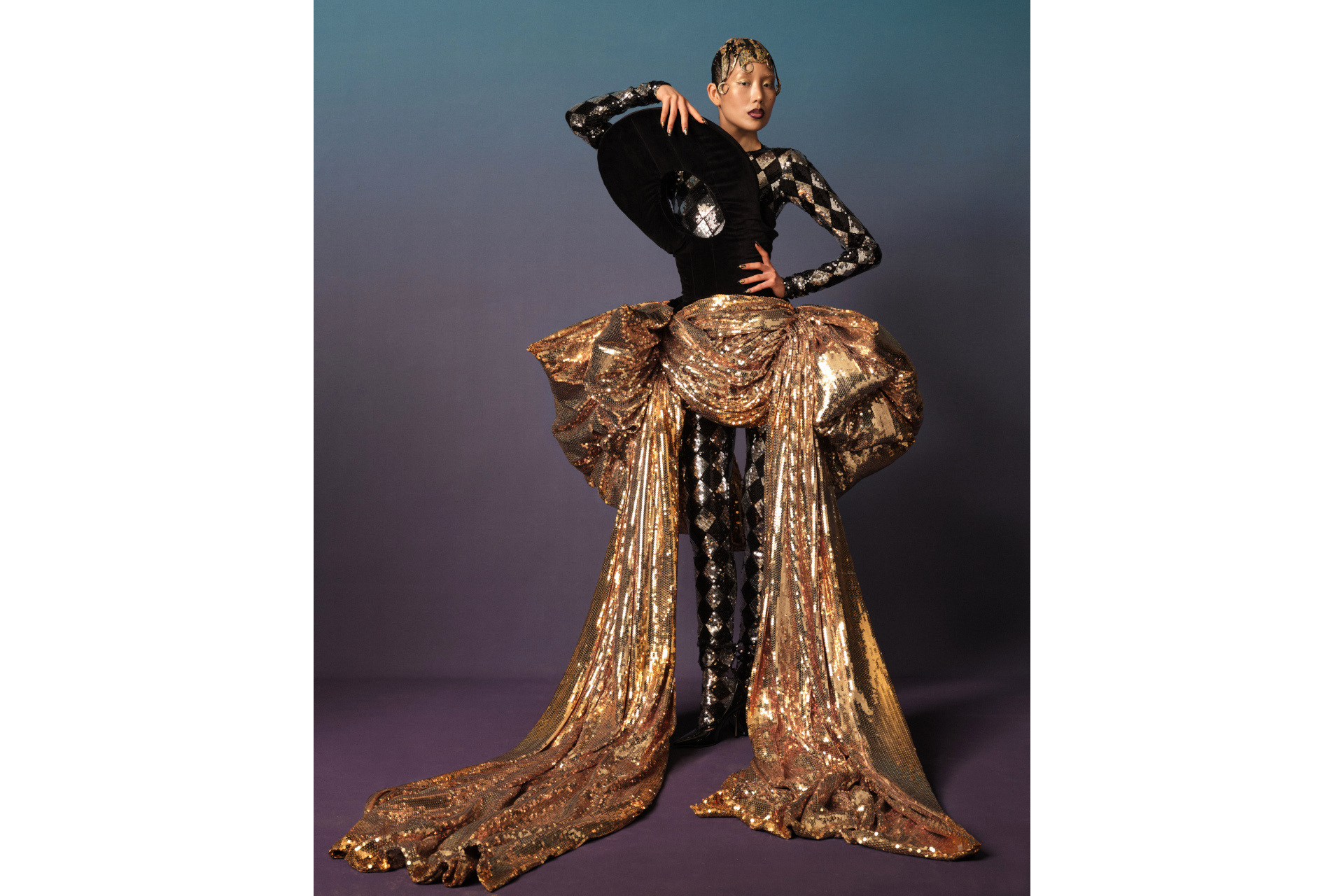 Woman in black and silver bodysuit with gold draped skirt