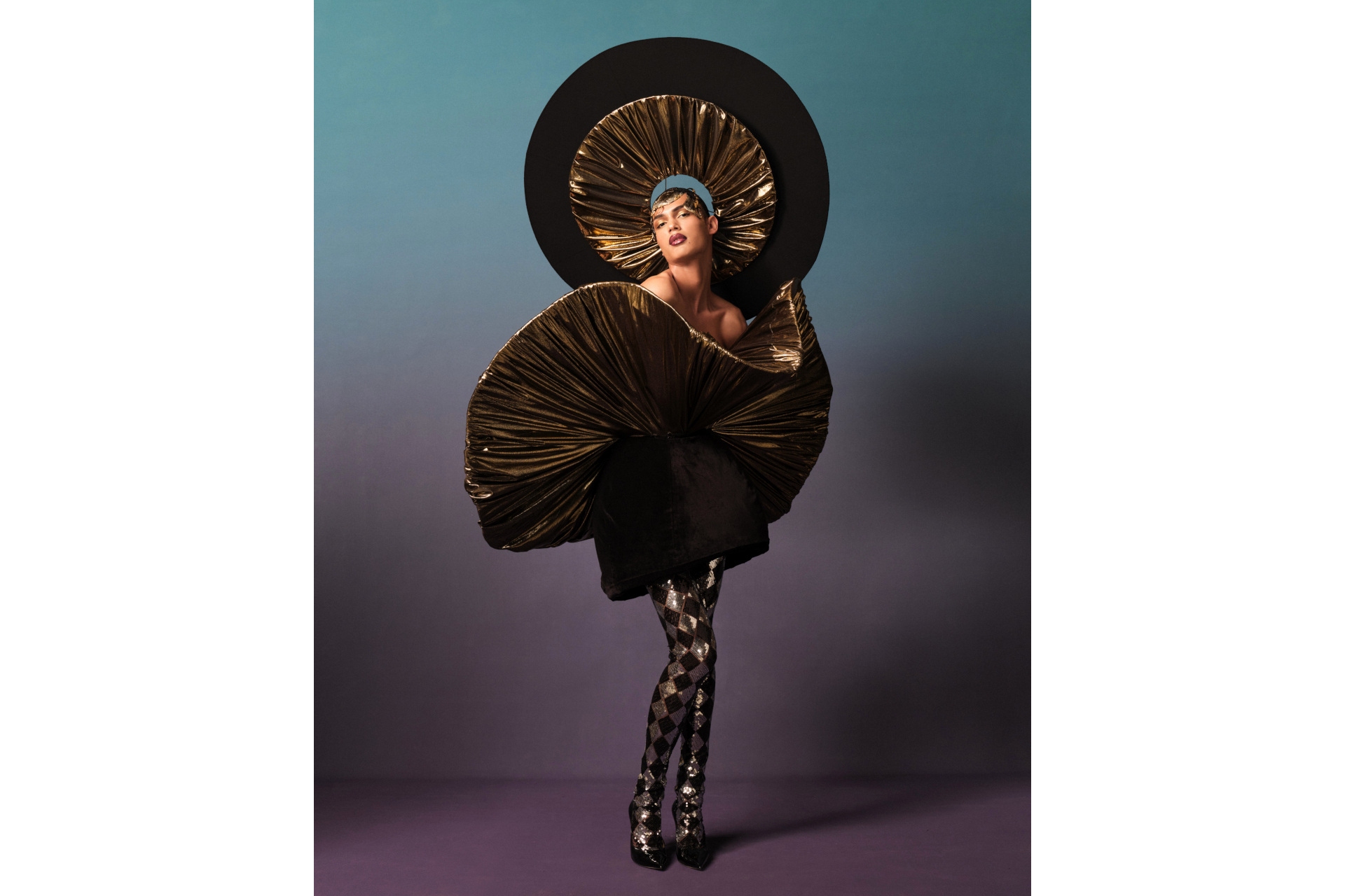 White model in black and gold dress and headpiece