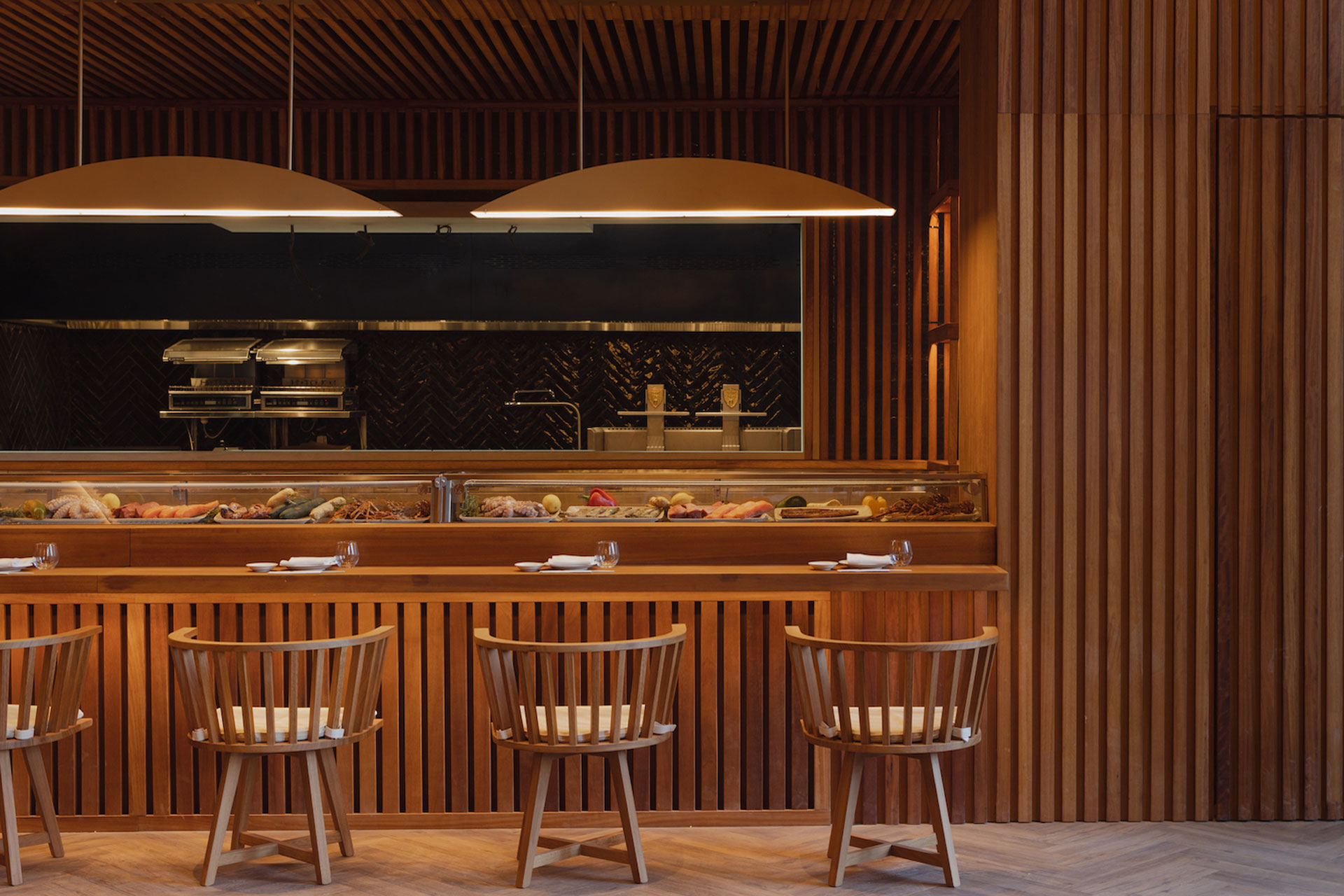 Restaurant at Nobu Hotel Marrakech, with bar stools and wooden panelling.