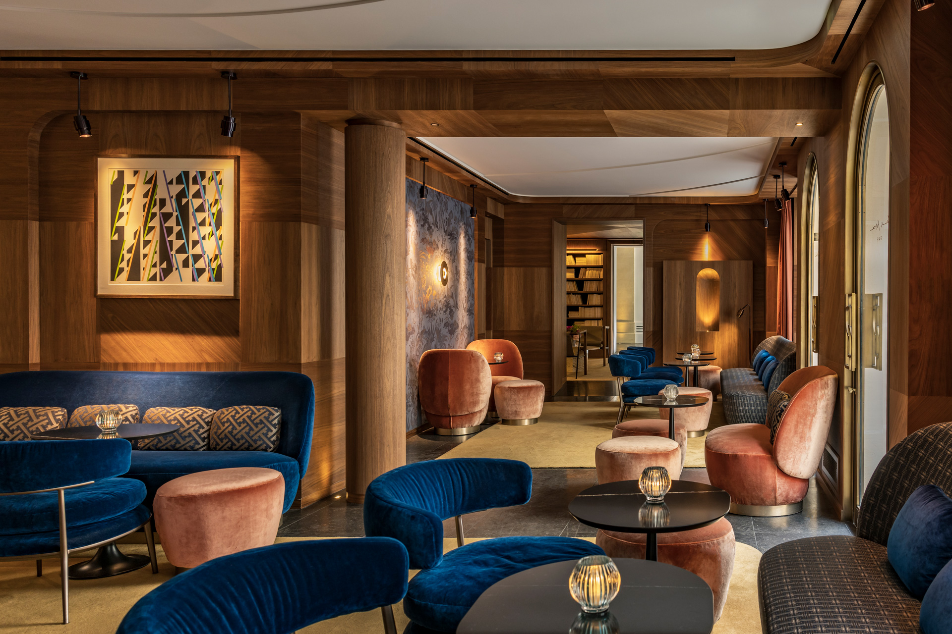 Bar at Pavillon Faubourg Saint Germain hotel, with blue velvet seats and black tables.