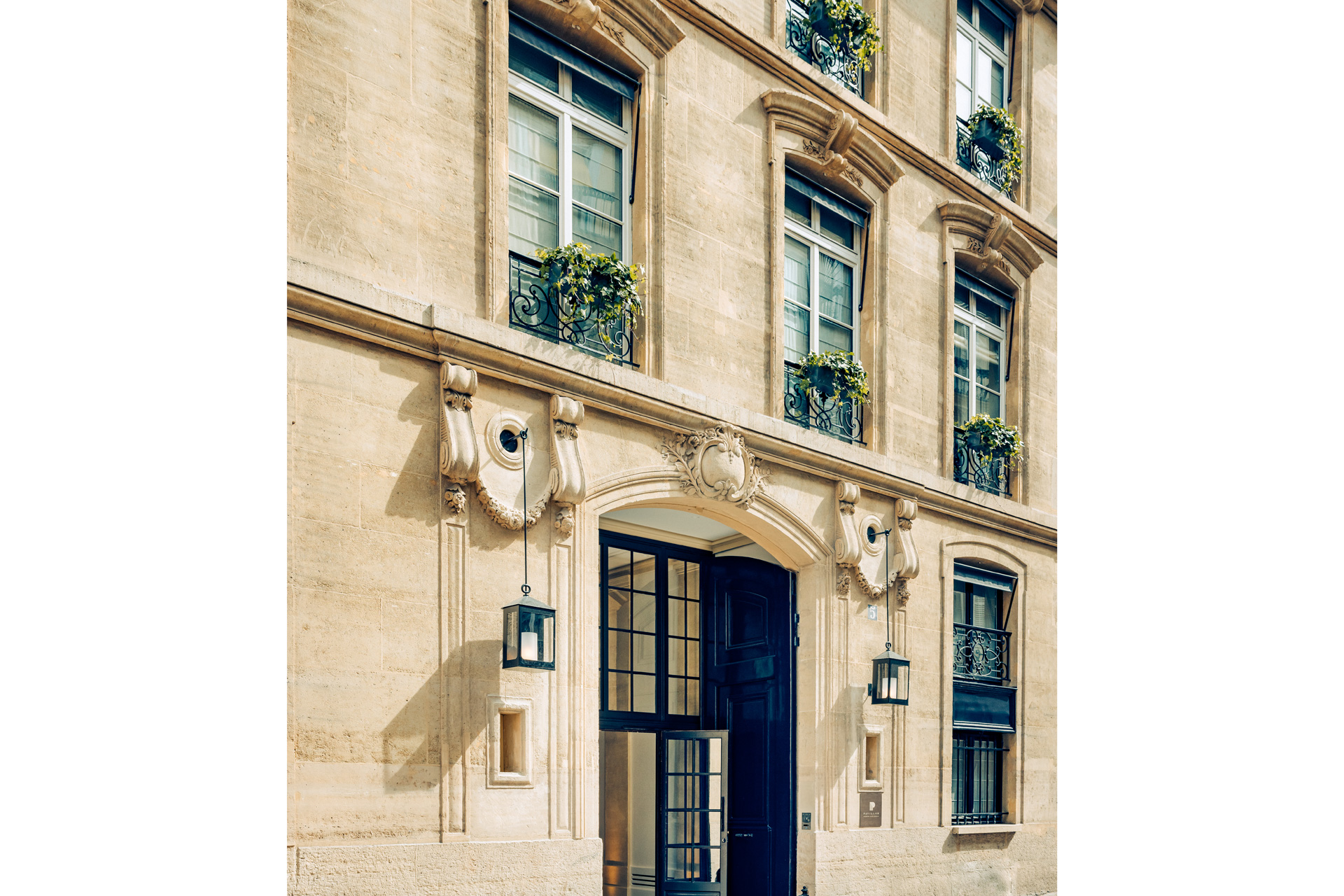 Exterior of Pavillon Faubourg Saint Germain hotel, with sandstone-coloured walls and black windows.
