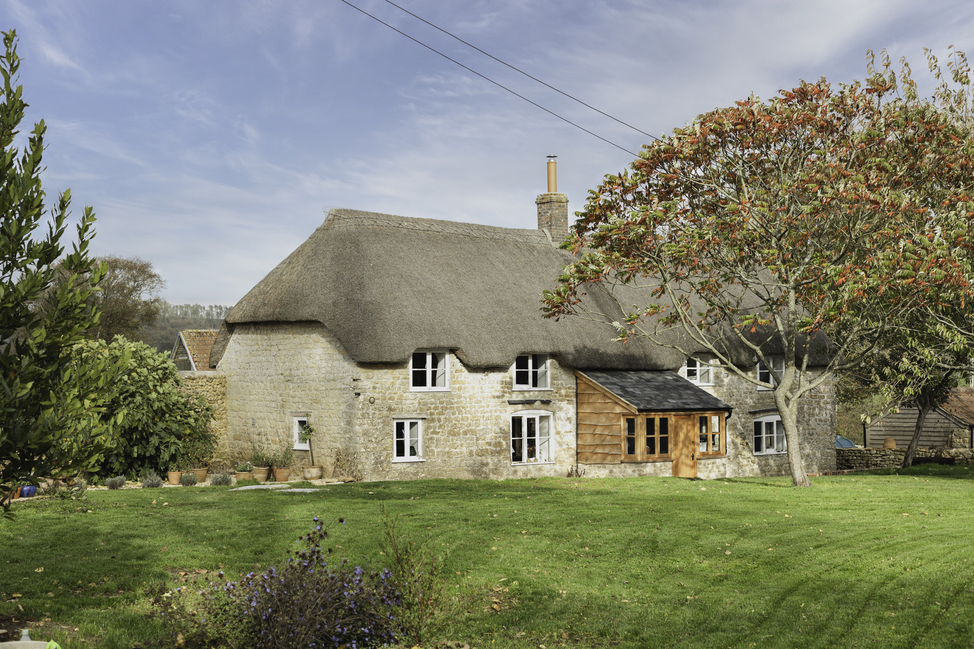 A cottage with a thatched roof, ideal for a weekend escape
