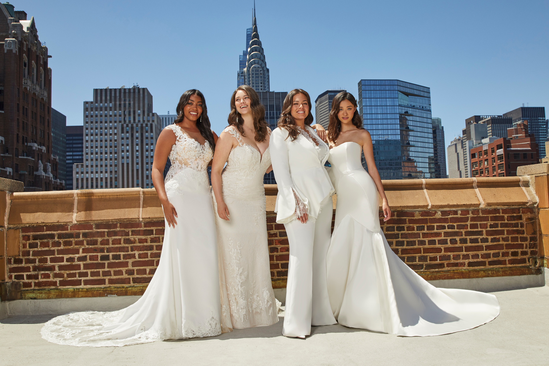 Four women in wedding outfits stood on top of building in city | bridal shops nyc
