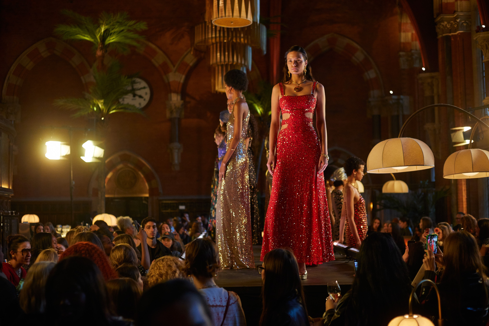 Models in evening gowns stood on raised platform in bar