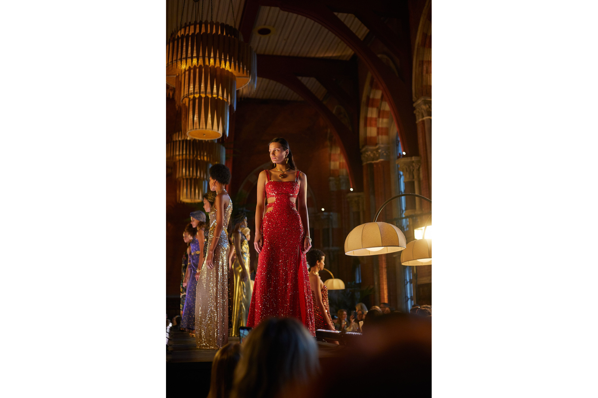 Models in evening gowns stood on raised platform in bar