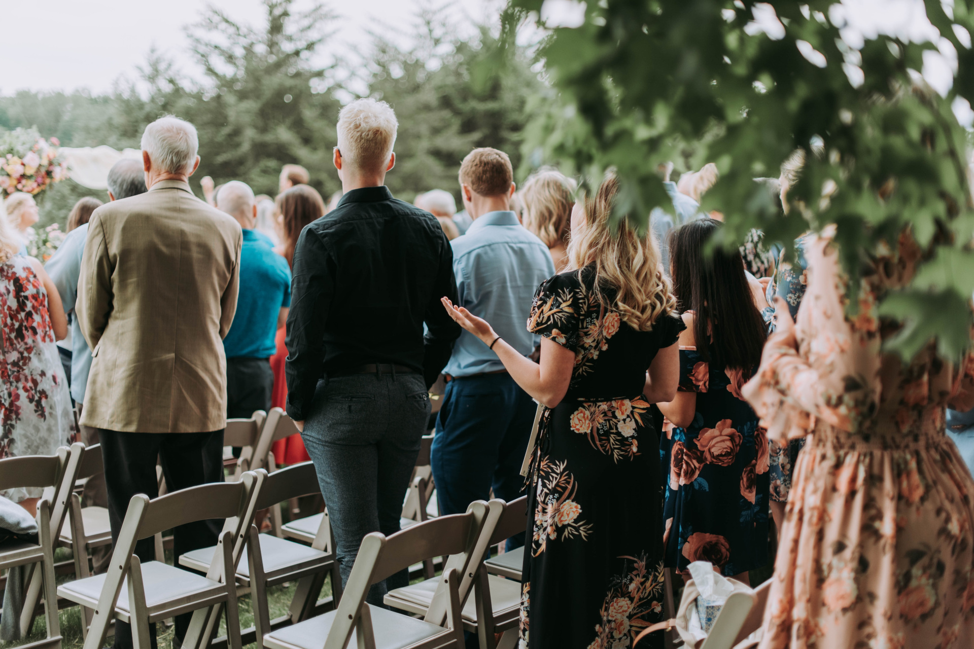 Guests at a wedding clapping while wearing formal outfits