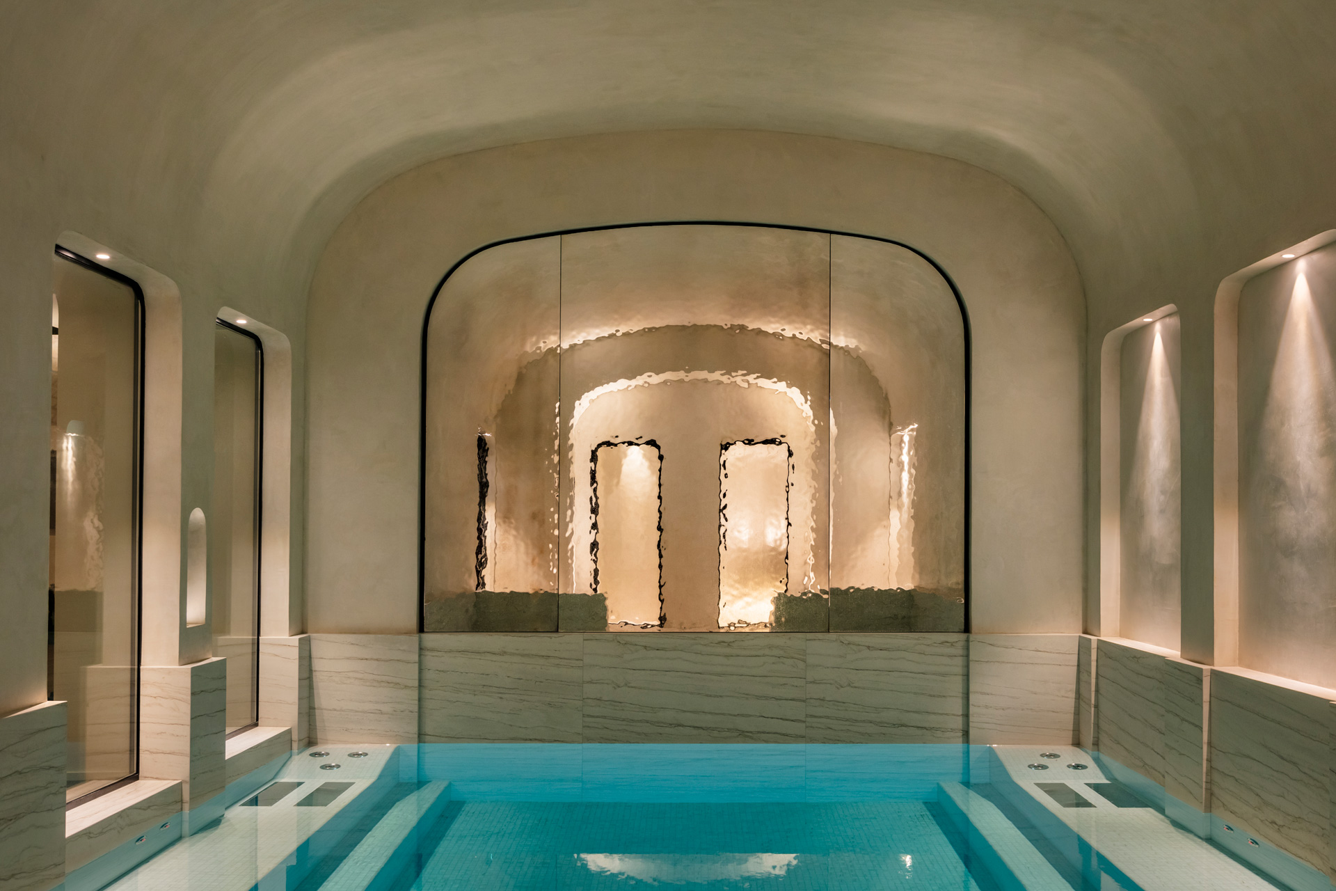 Spa at Pavillon Faubourg Saint Germain hotel, with cream concrete walls and a swimming pool in the centre.