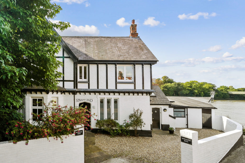 White home on the riverside with black beams