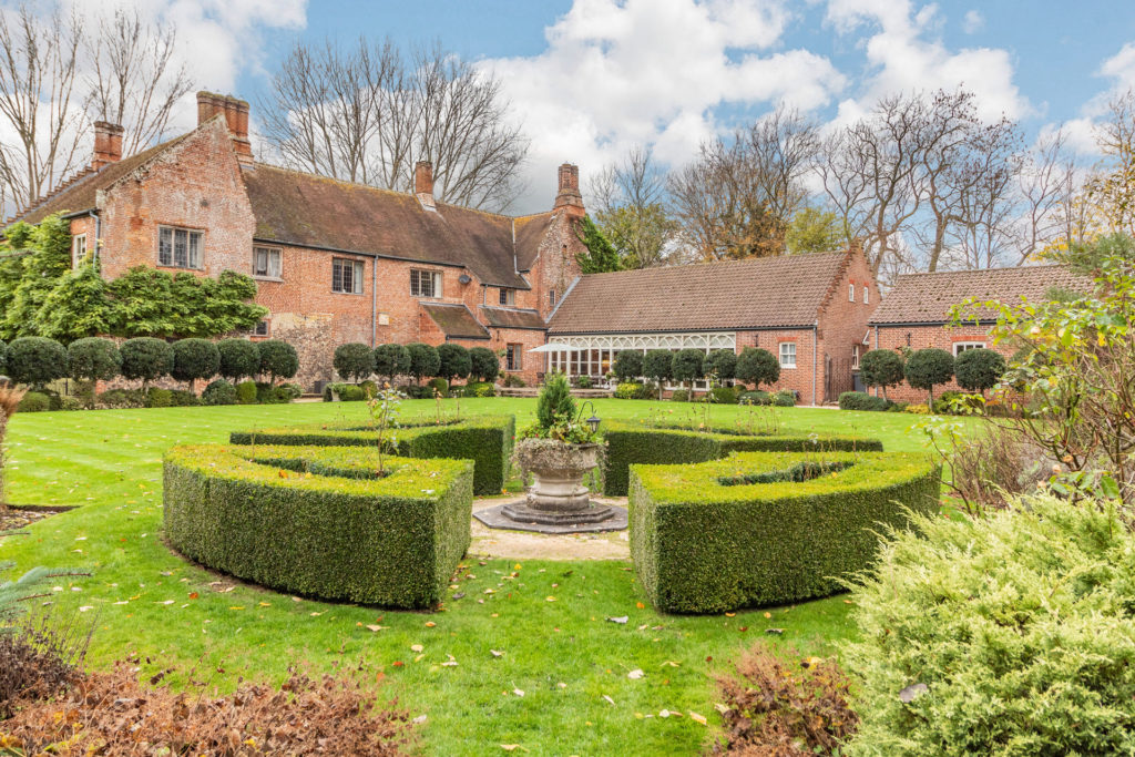 Gardens of Swannington Hall, Norwich, featuring landscaped hedges and a fountain.