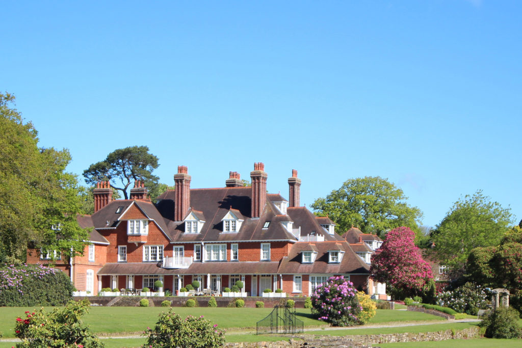 Large manor house with red brick exterior and landscaped gardens
