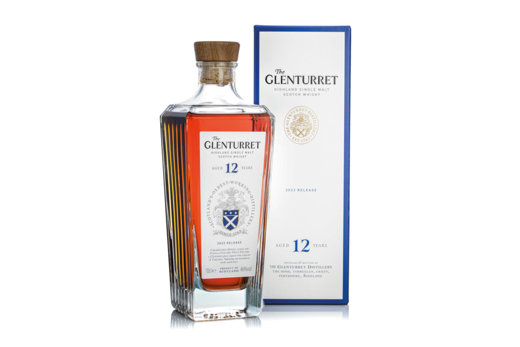 Bottle of whisky next to blue and white box