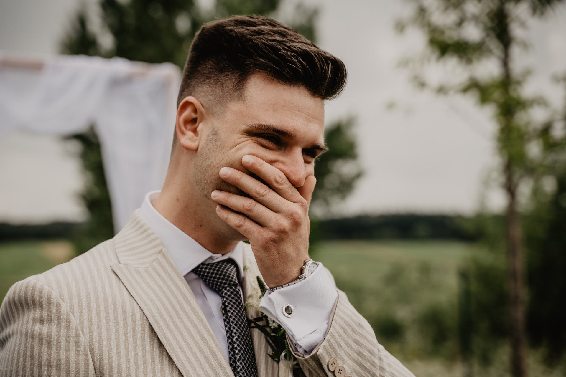 Close up on man in strip suit covering his mouth