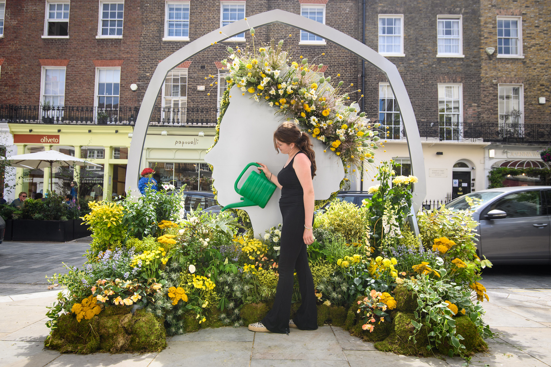 Florist Claudia Costil from Moyses Stevens puts the finishing touches to a floral installation of a 50 pence piece featuring the Queen’s Head on Elizabeth Street in London