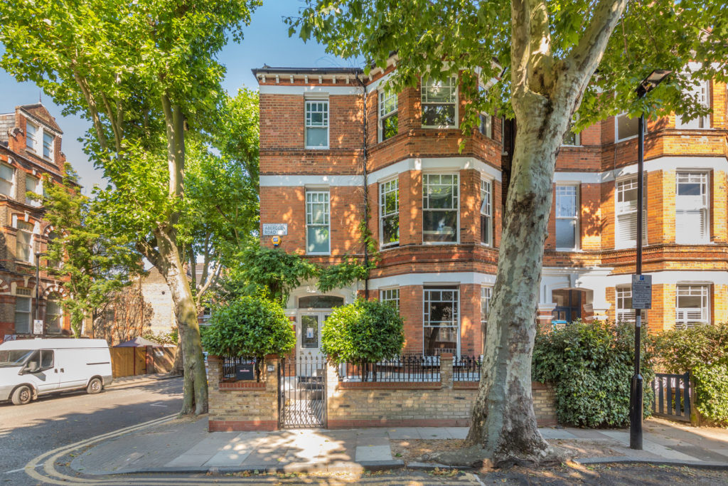 Red brick terraced houses with trees lining the street.