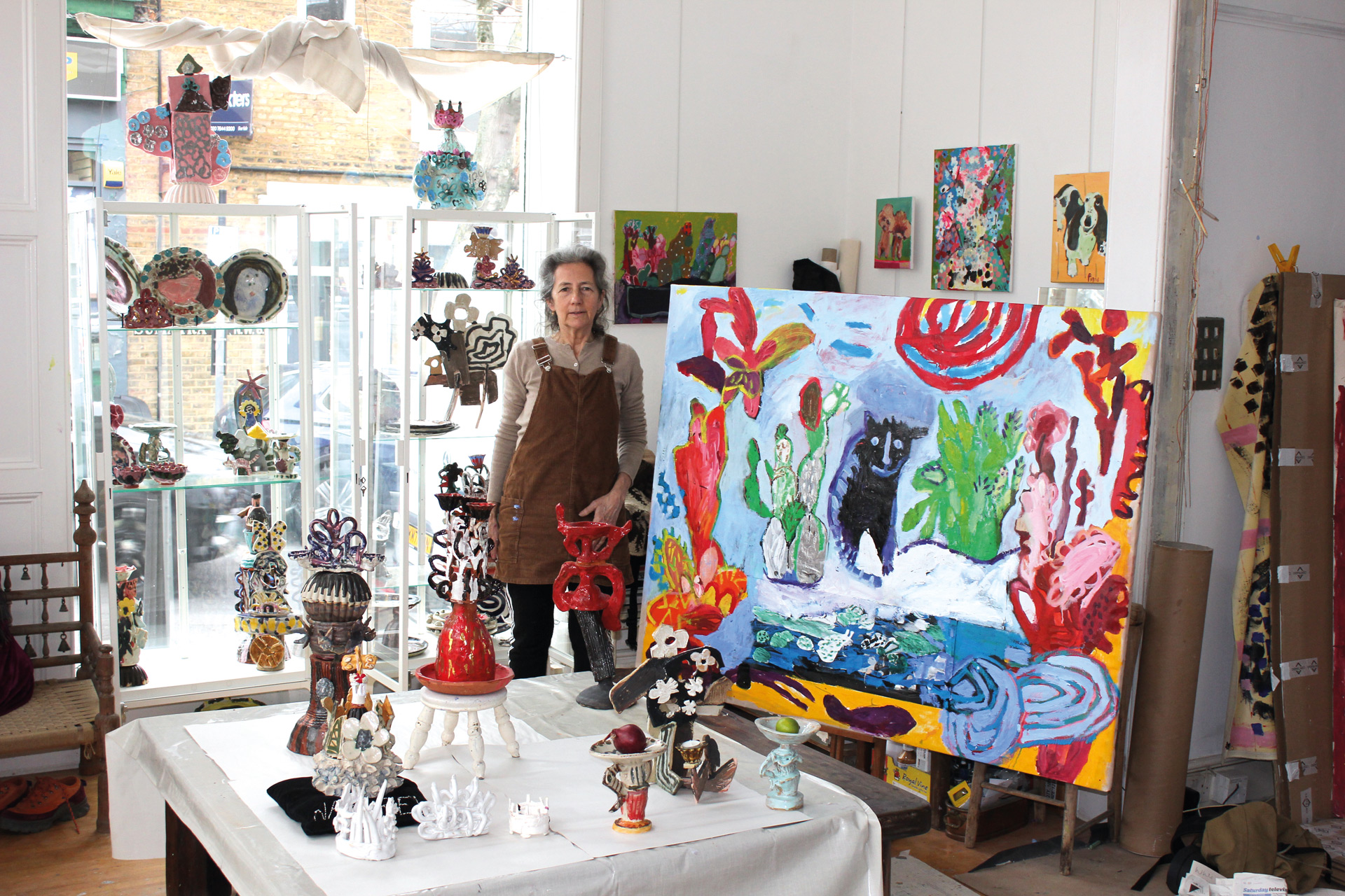 Louise Kaye in her Hampstead studio beside a colourful painting on an easel