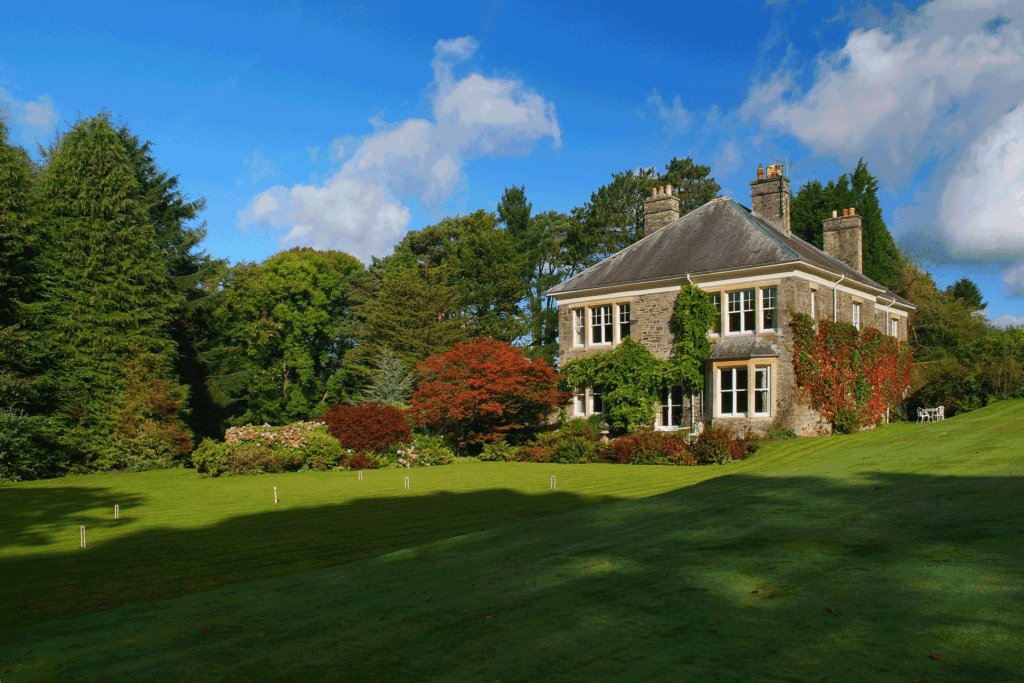 Large country manor with fields surrounding and ivy-covered brick