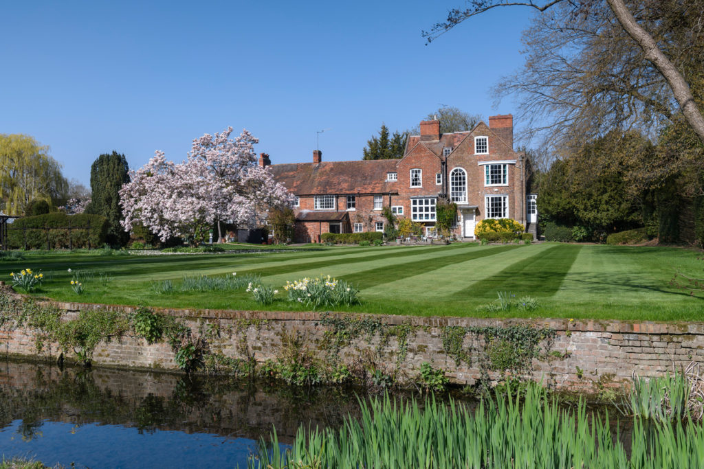 Riverside property with red brick exterior and outbuildings.
