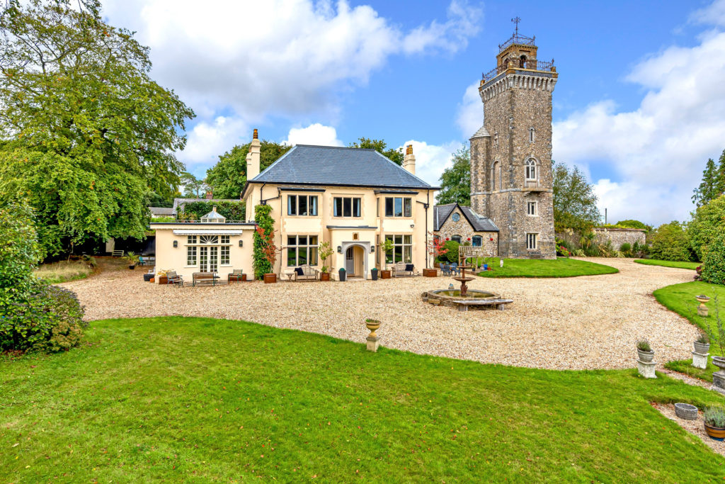 Light brick house with slate house and a tower beside.