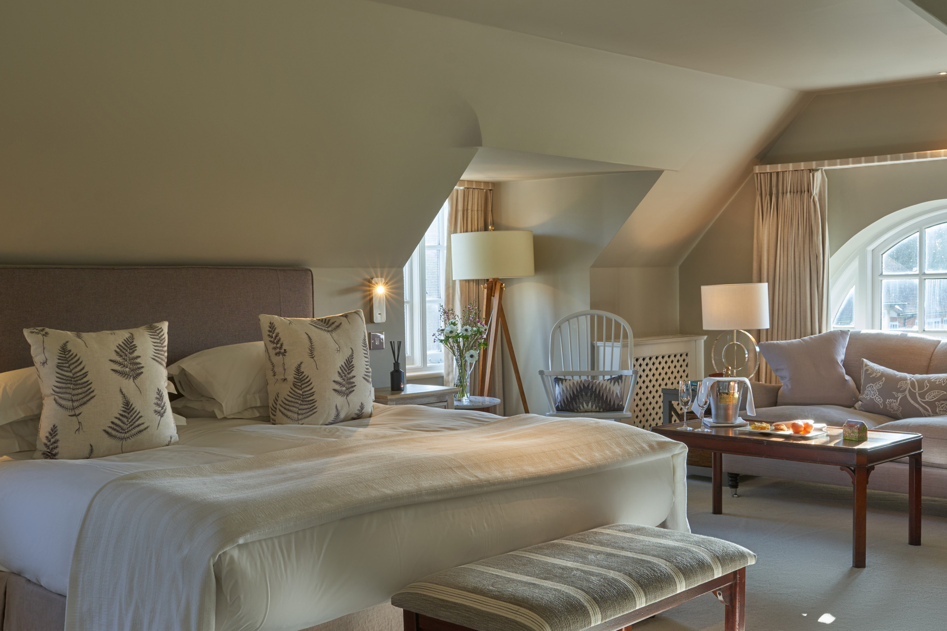 Bedroom with arched window, beige headboard and grey accents