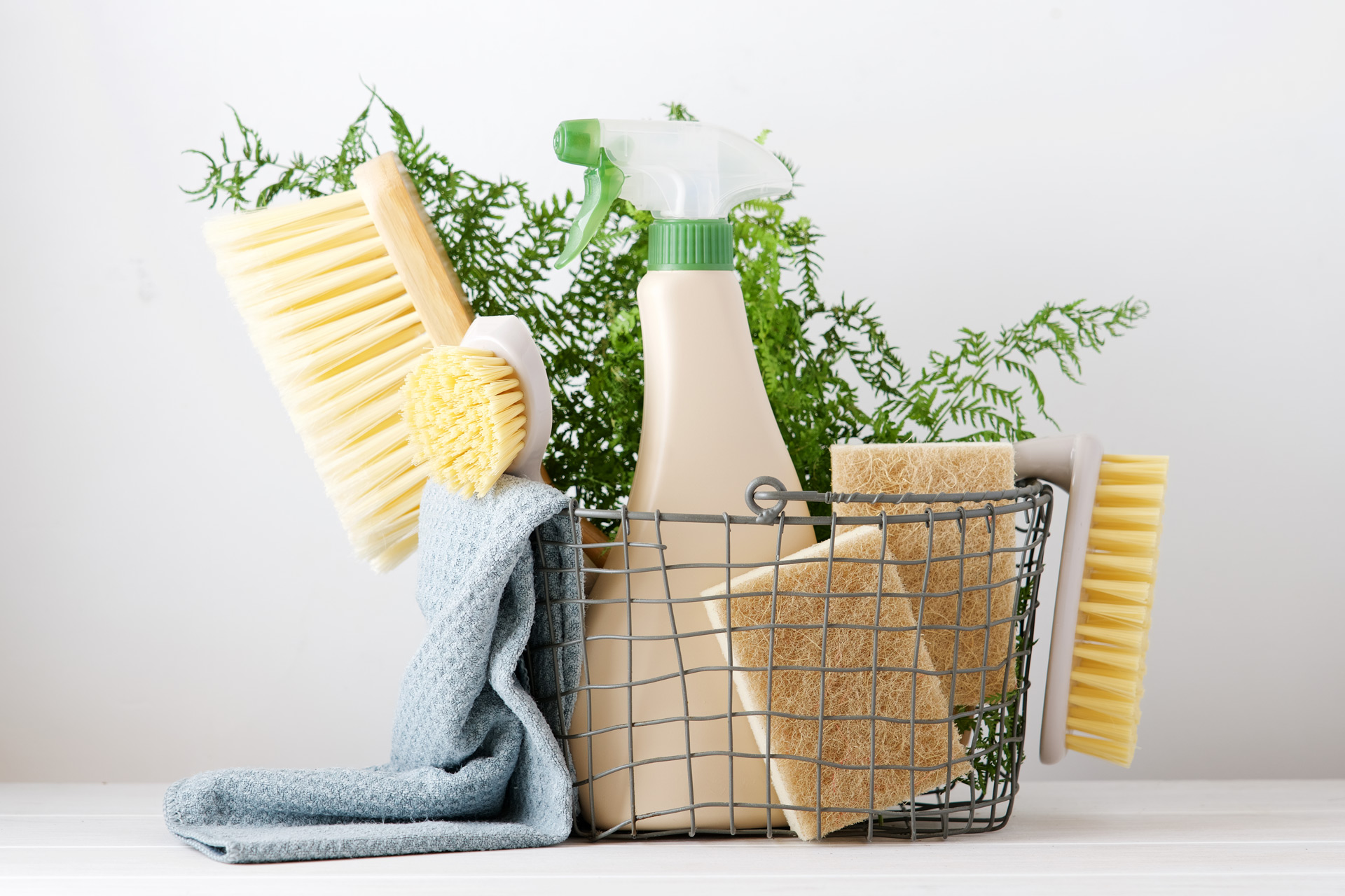 Wire basket with eco-friendly cleaning sponges and spray bottles