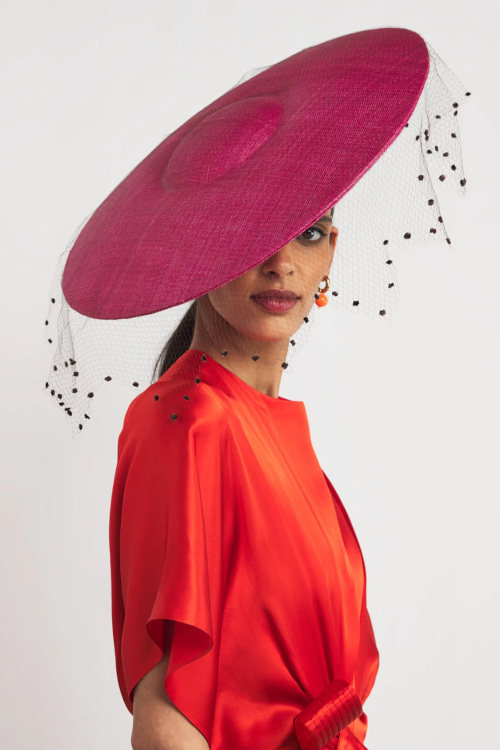 Woman wearing red top and pink hat