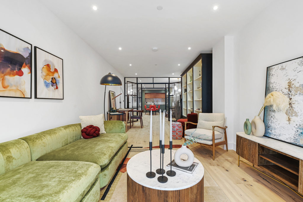 Loft-style apartment with light green velvet sofa and dark wood accents