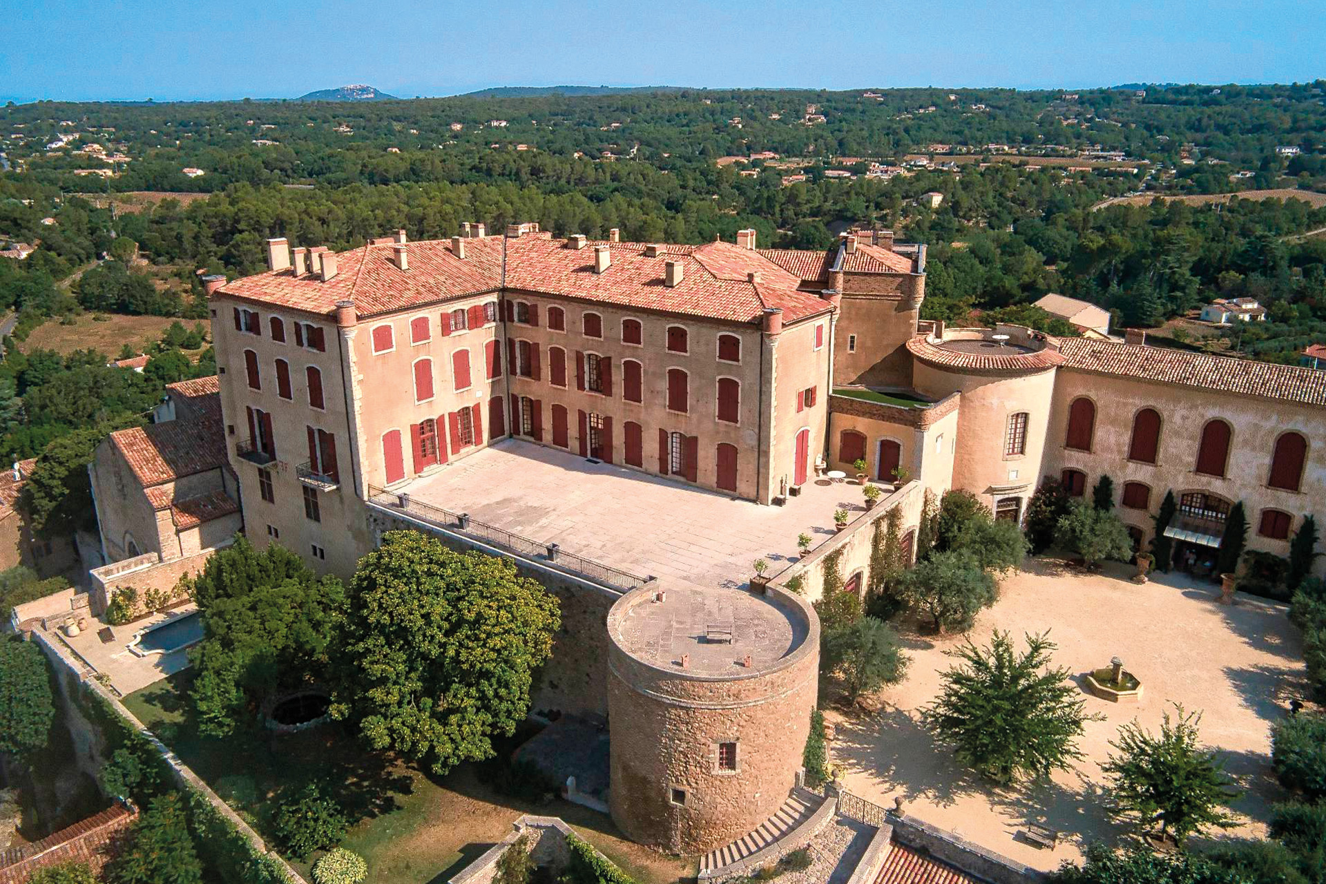 Chateau in Provence with large courtyards and greenery beyond