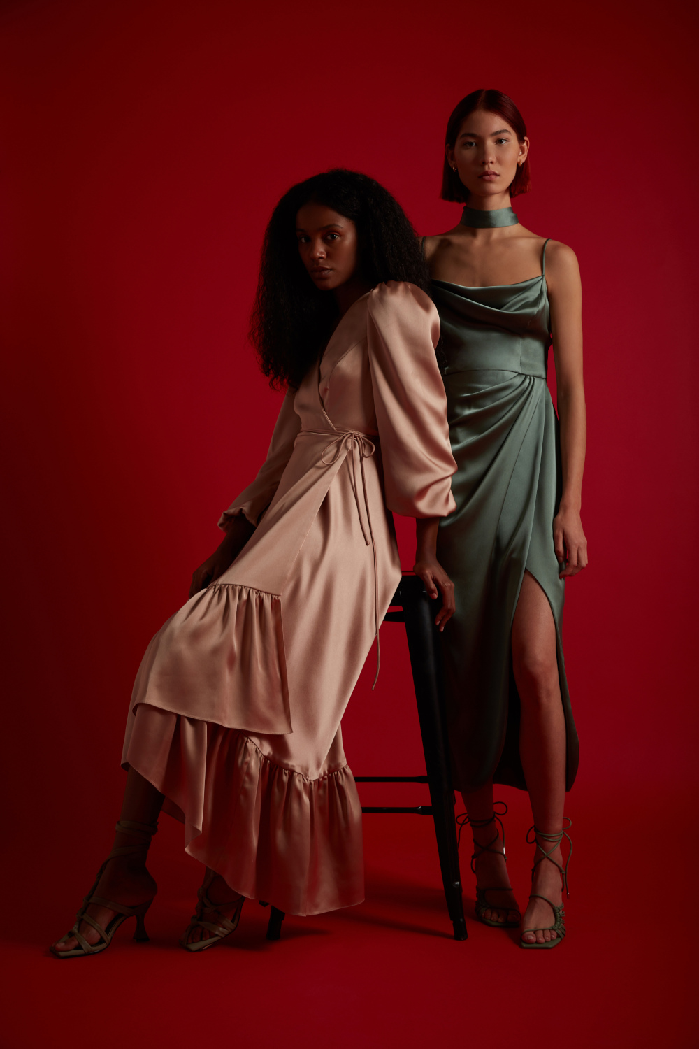 Women leaning against stool wearing bridesmaid dresses