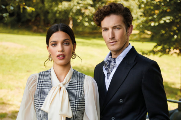 Man and woman in suits stood in garden