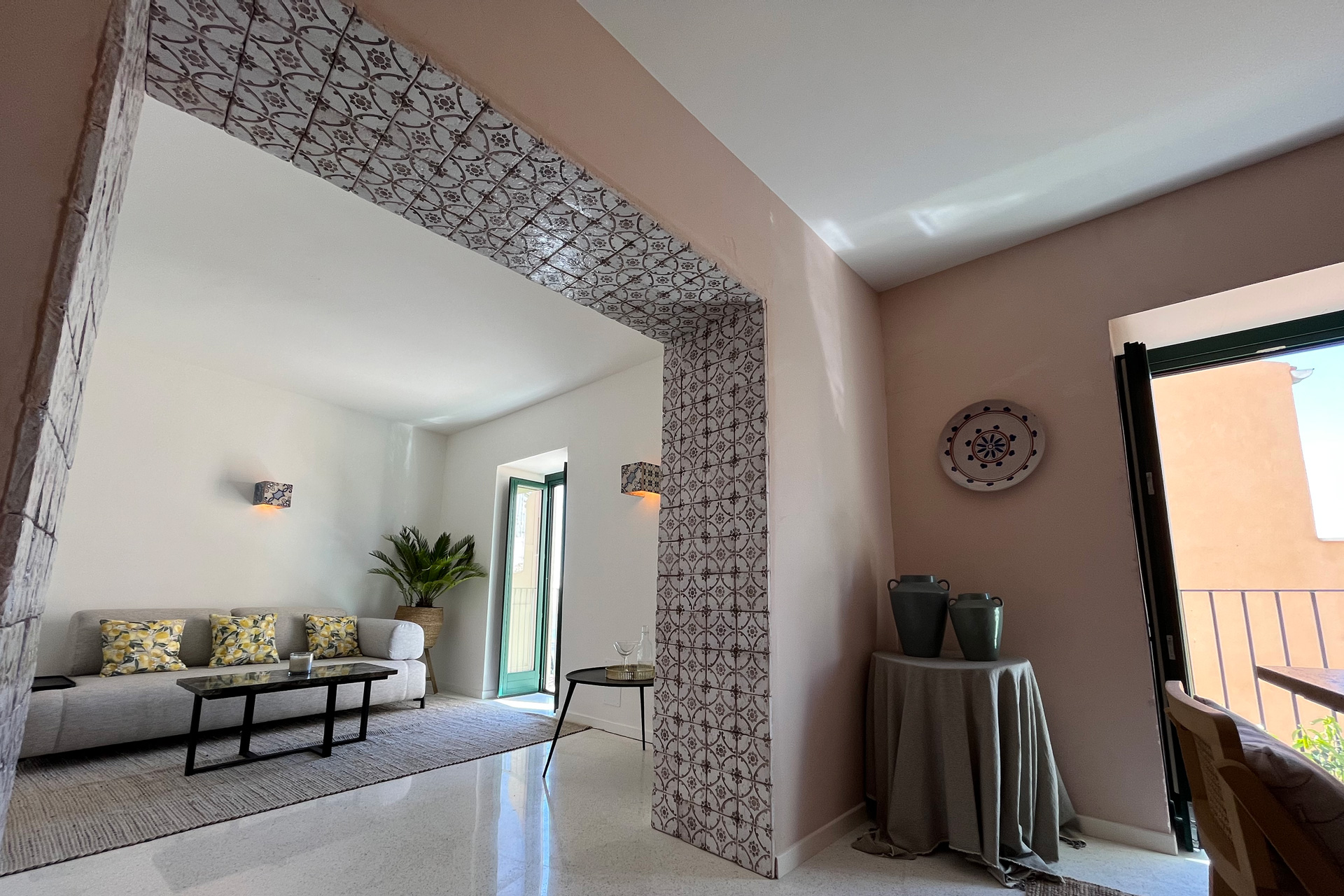 Dining room with pink walls and a blue-and-white tiled archway