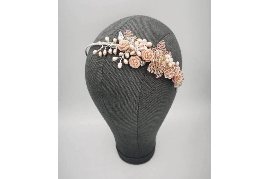 Grey mannequin wearing pink floral headpiece