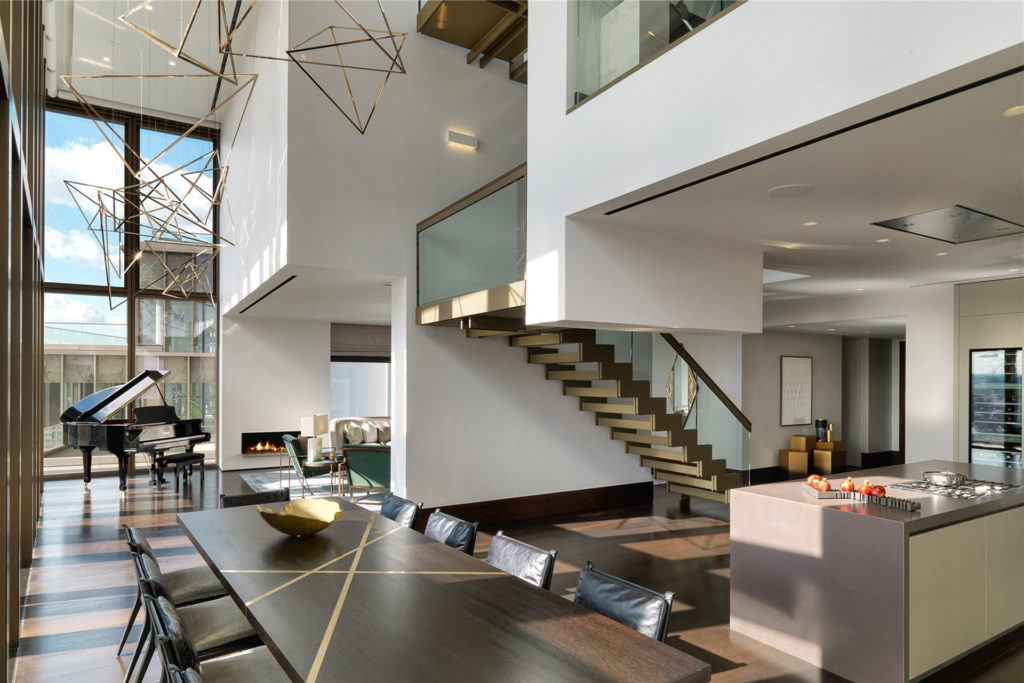 Penthouse with high ceilings, dark wooden furniture, and an exposed oak staircase