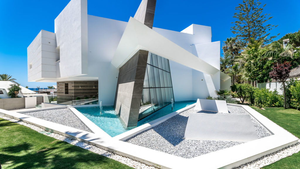 Spanish villa with a triangular outdoor swimming pool and a hexagonal driveway.