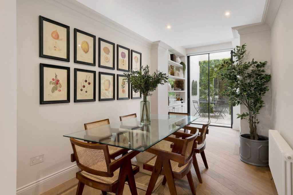 Dining area with rattan chairs, glass table and sliding glass doors leading out to the patio.