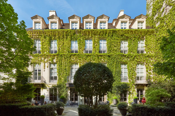 Hotel exterior with ivy-clad walls and a large landscaped hedge in the centre of the front courtyard
