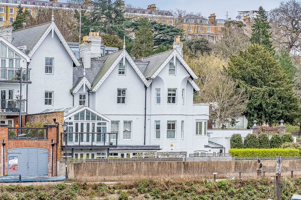 White painted riverside property with conservatory.