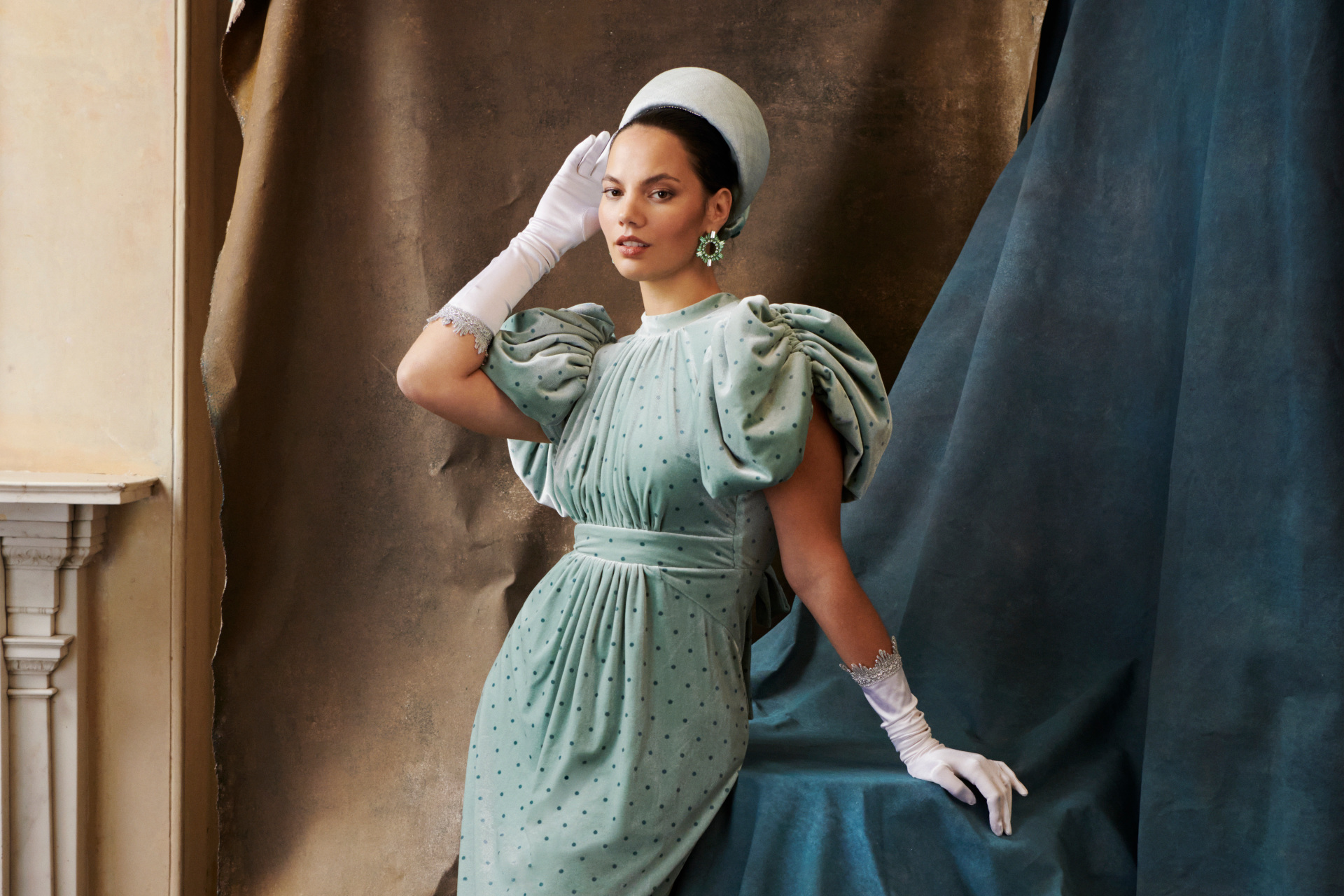 Woman in blue dress wearing white glove and hat