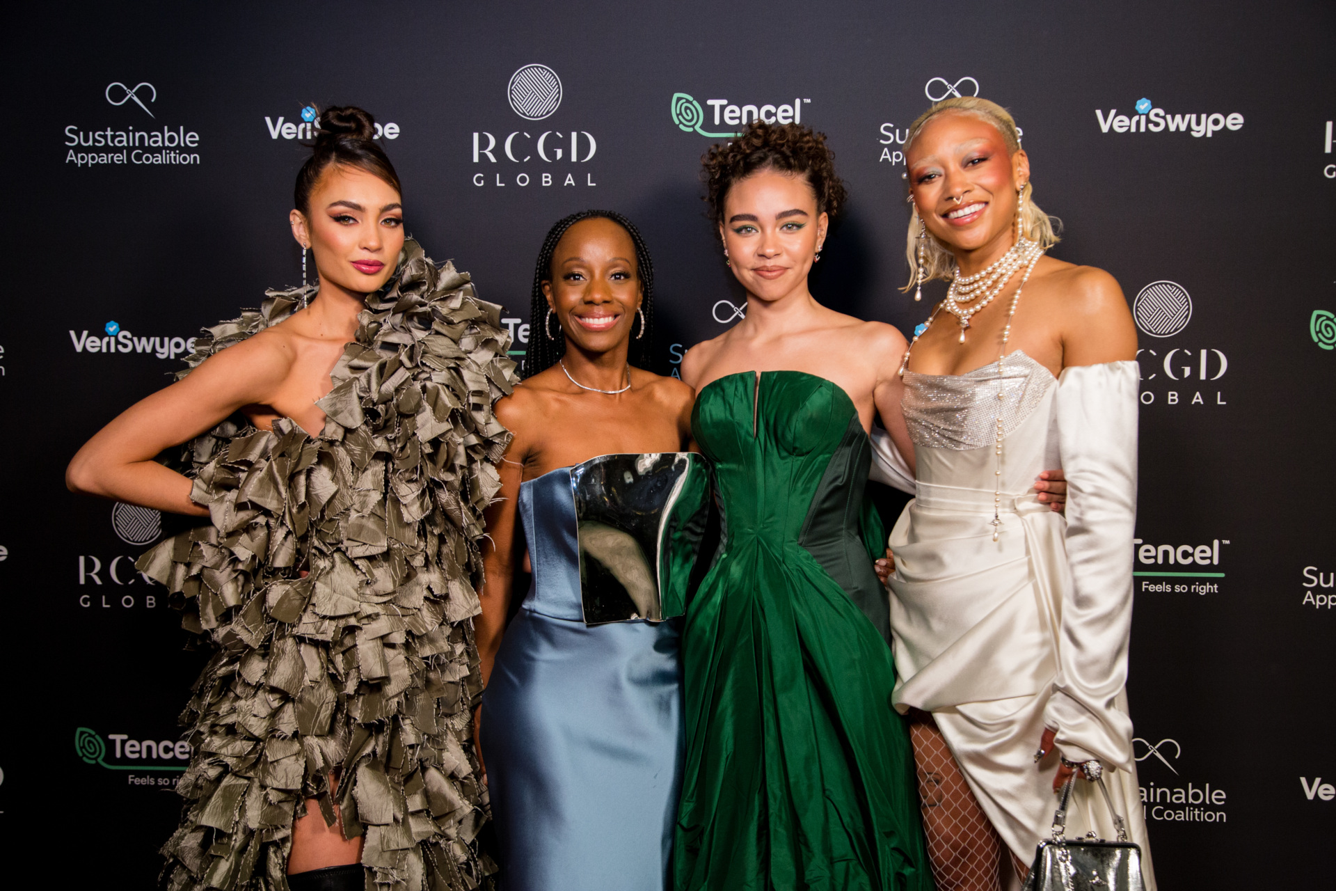 Four women posed together wearing evening dresses