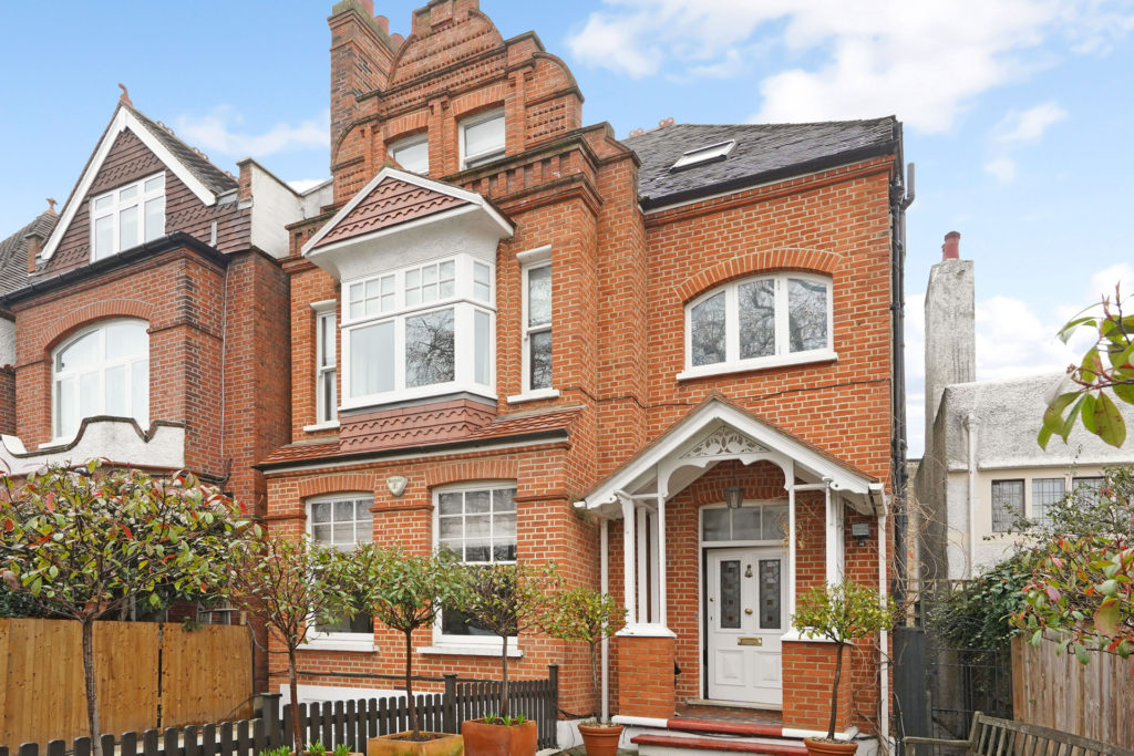Red brick house with white features and a large loft extension