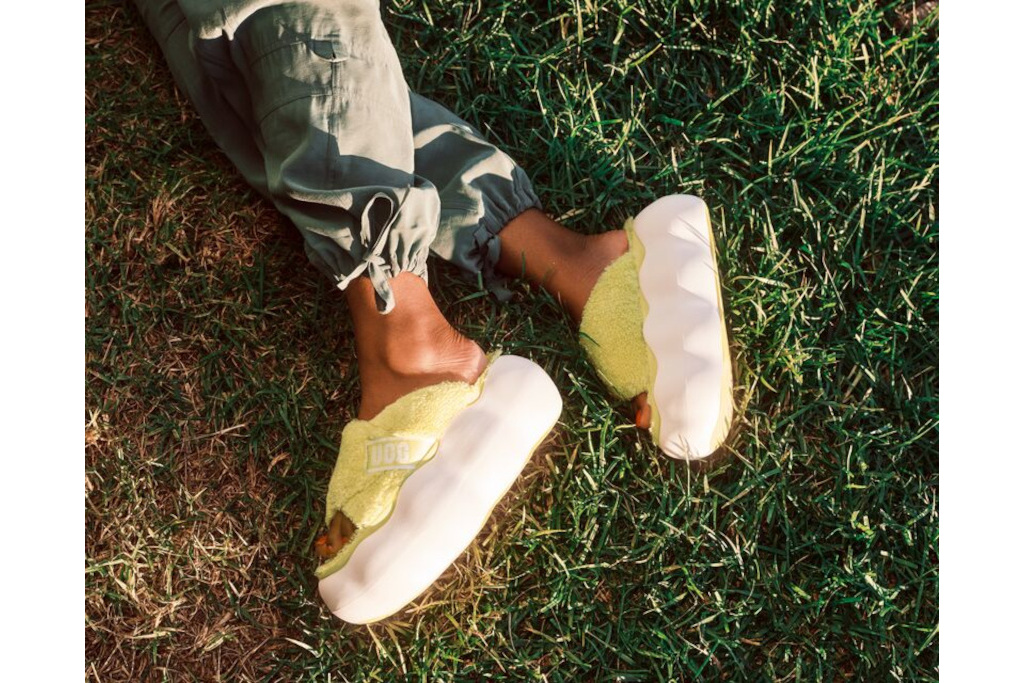 Close up of feet wearing yellow UGG slides