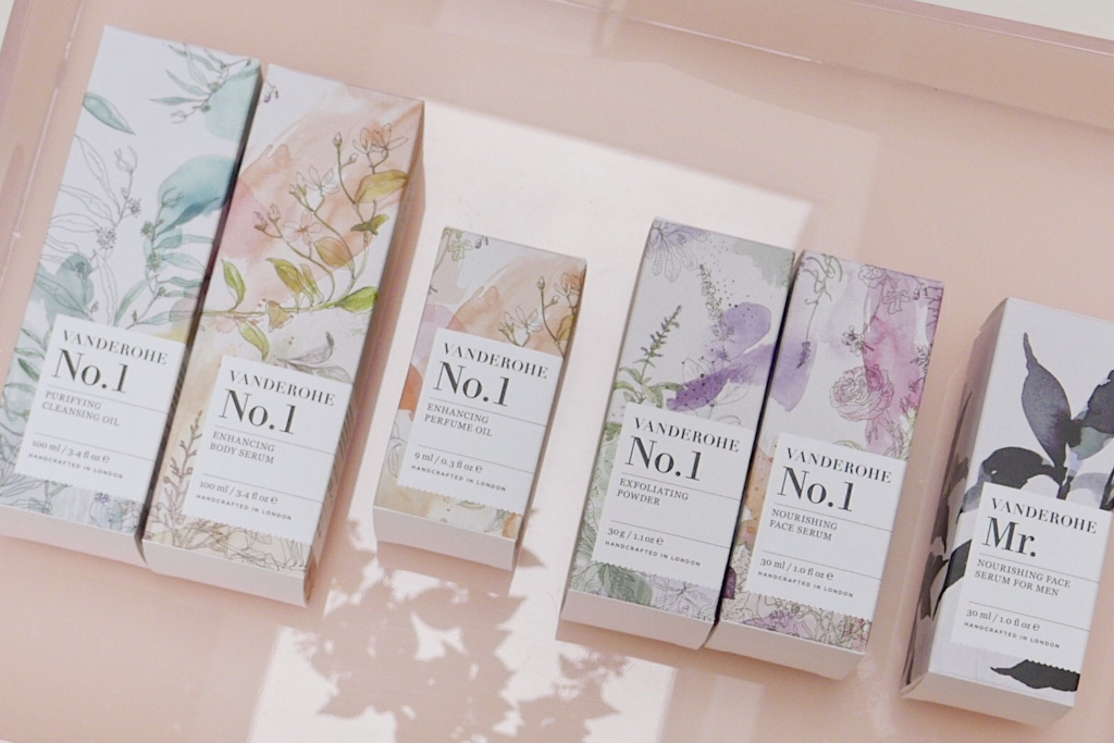 Boxes of skincare products on pink reflective surface