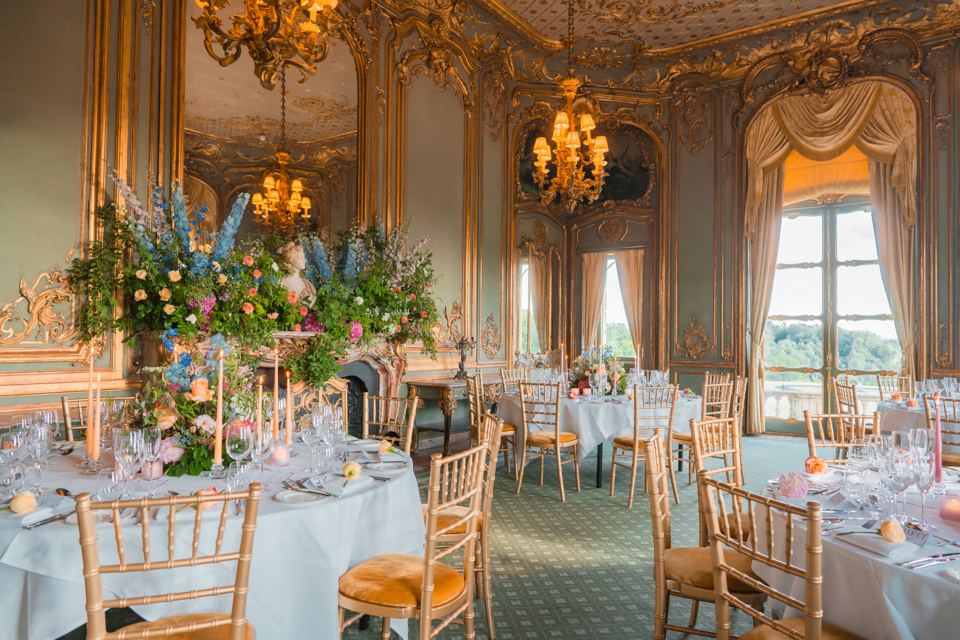 Ornate dining room with tables laid with floral arrnagements