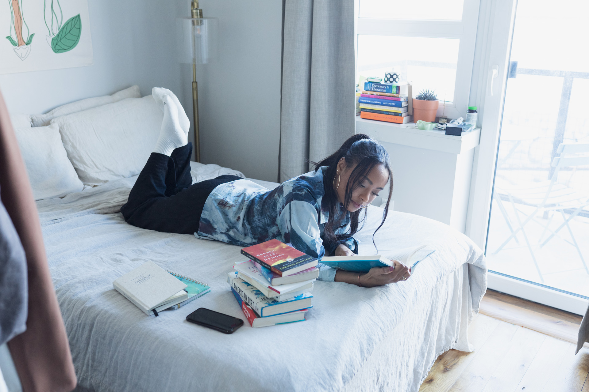 a woman reading beside a stack of books