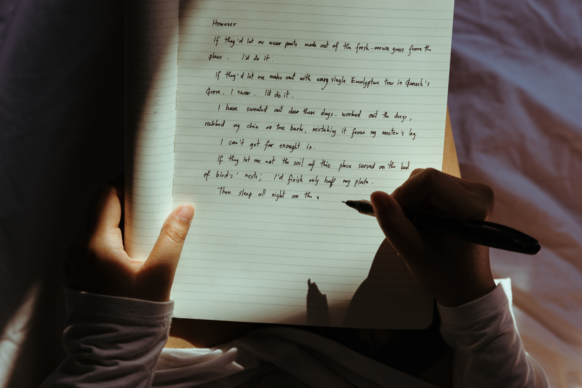 A person writing in a slice of light