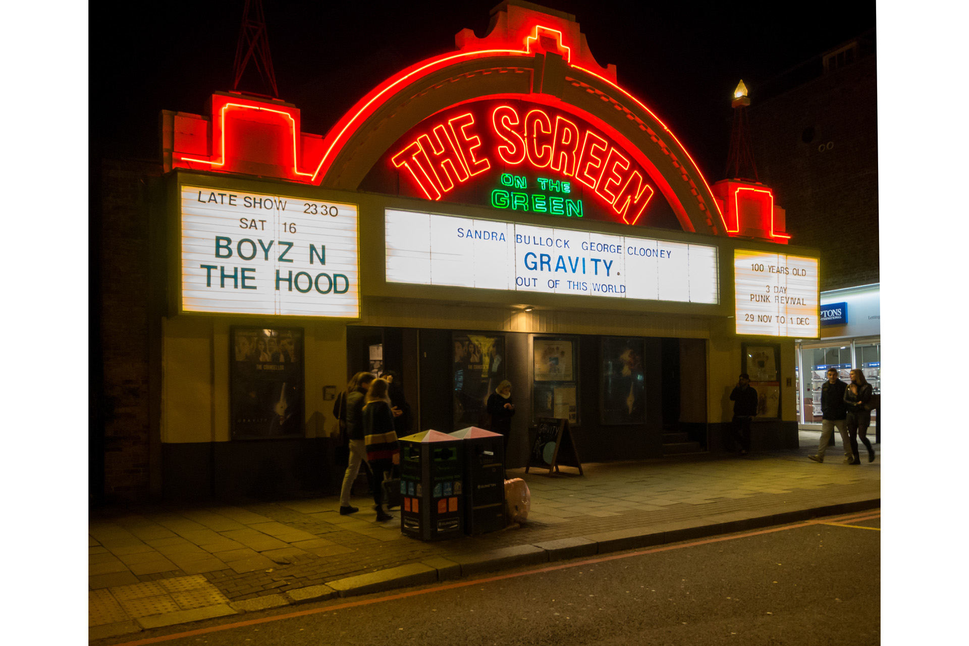 London, UK - November 10, 2013: The Screen On The Green cinema in London's Islington at night with people passing-by