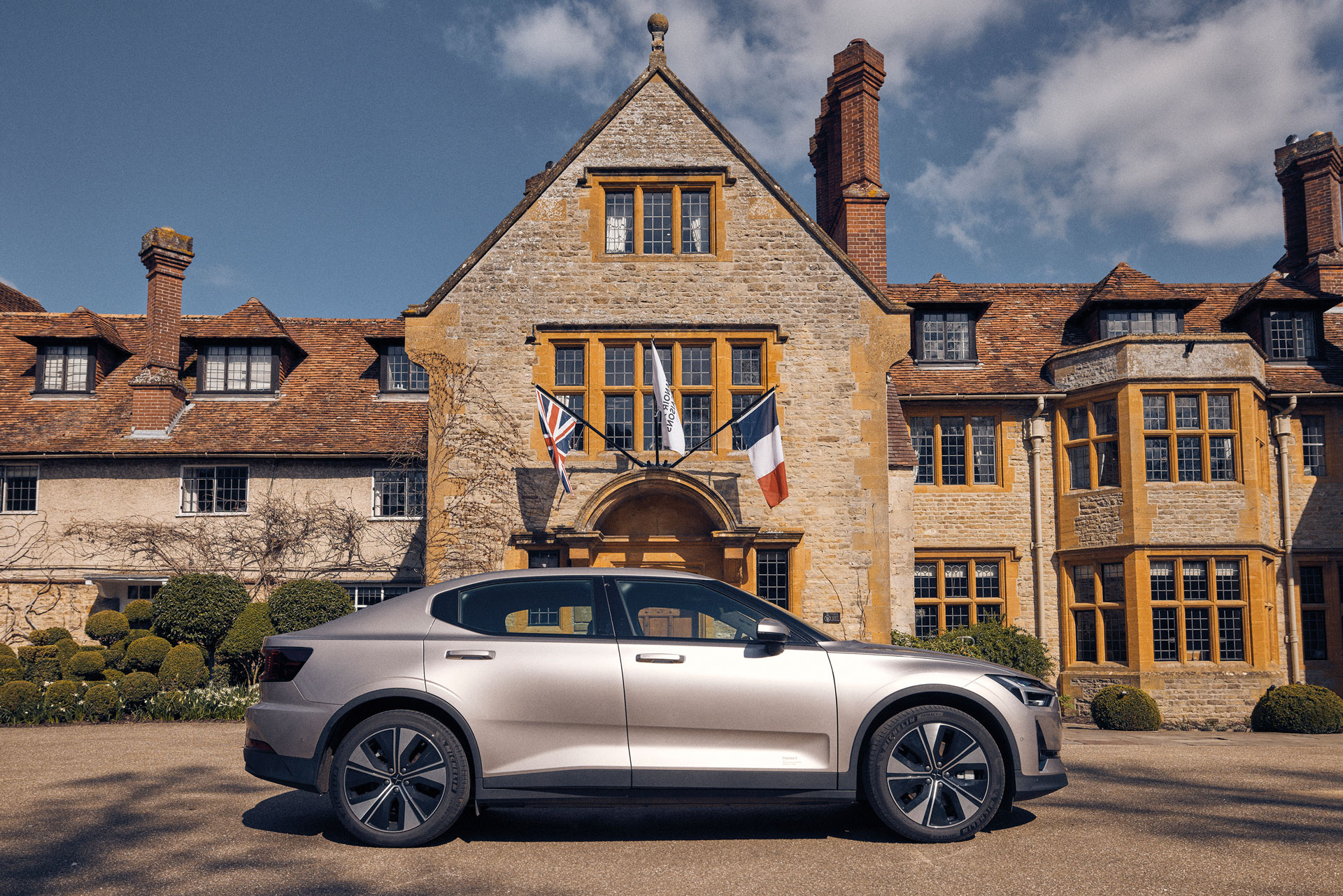 The exterior of Le Manoir aux Quat'Saisons with a Polestar 2 parked in front for Sustainable Hotel Award