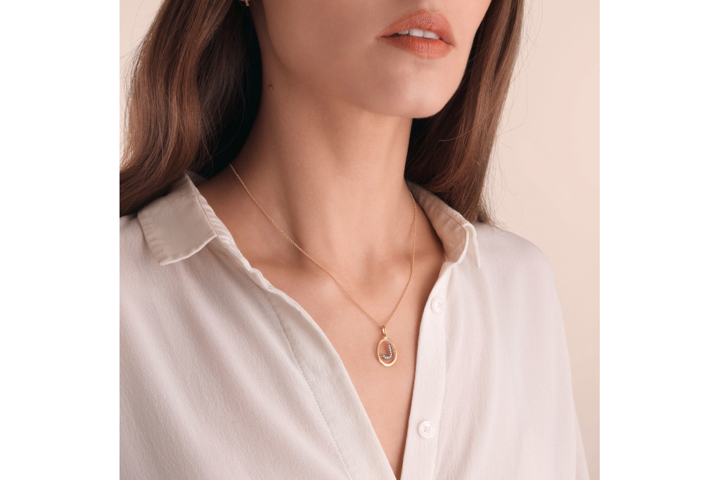 Close up of woman wearing letter pendant