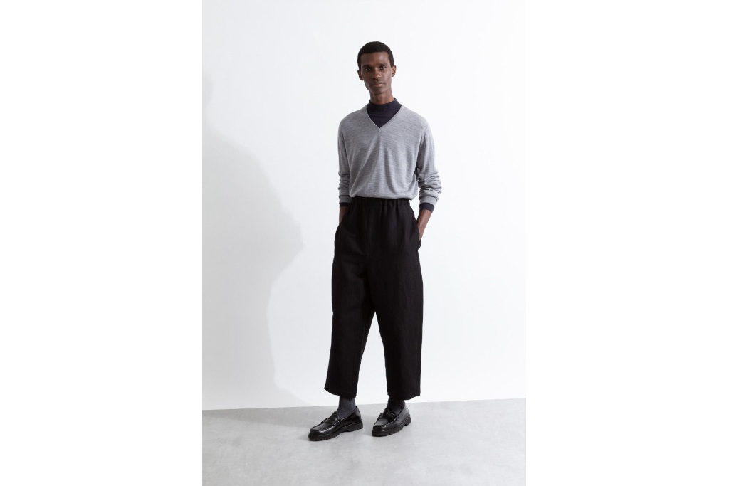 Man in grey sweater and black trousers